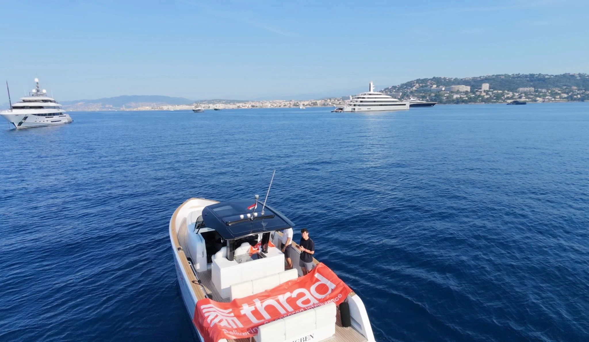 The Thrad boat off Cannes during the festival, with superyachts and the Croisette behind it